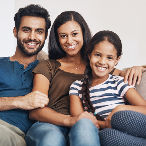 family smiling on couch