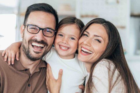 Family smiling together to promote healthy cavity-free dental habits in Columbus, OH.