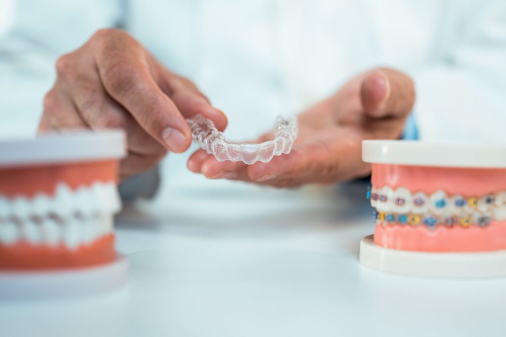 A dentist comparing clear aligners and braces at an orthodontic consultation in Columbus, OH