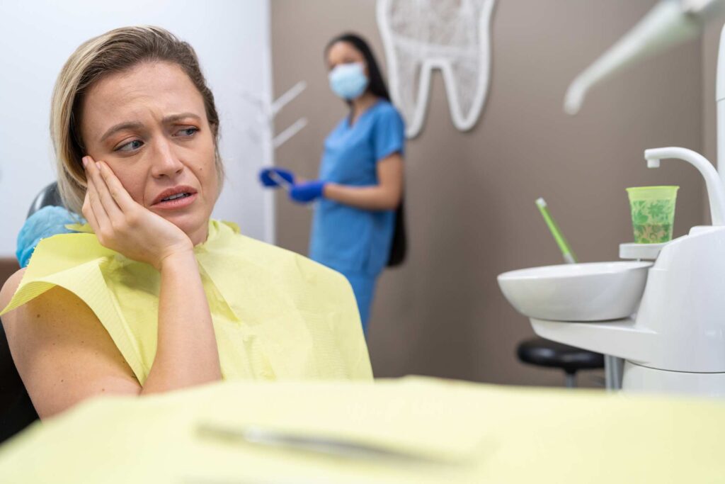 A woman awaiting emergency dental treatment for sudden tooth pain in Columbus, OH